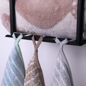 Bathroom wall-mounted storage rack detail shot showing hanging towels on metal hooks.