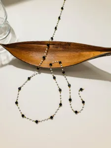 Détail de chaîne perlée DIY en acier inoxydable, perles blanches et noires pour bijoux.