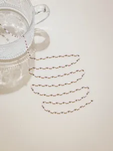 Pink glass tube bead chain detail closeup, ideal for DIY jewelry making and craft design.