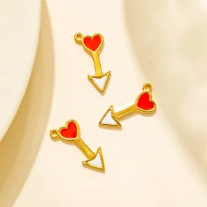 Détail de pendentif flèche cœur émaillé en acier inoxydable avec design rouge et blanc.