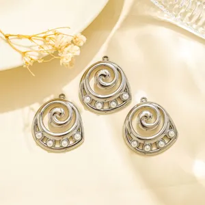 Detailed close-up of three silver spiral DIY metal pendant charms with pearl accents.