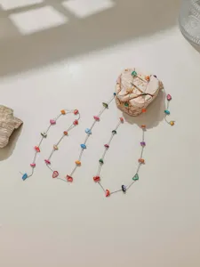 Close-up detail of colorful beaded chain featuring bohemian multi-color stones on metal.
