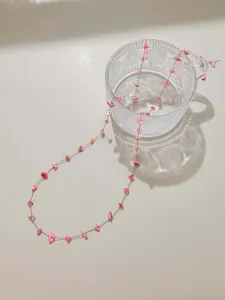 Delicate gold chain with pink irregular stone beads detail shot, perfect for DIY summer jewelry.