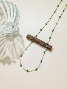 Vue de detail en gros plan d'une chaine de bijoux DIY avec des disques verts.