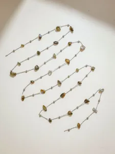 Close-up detail van roestvrij staal natuurlijke gemengde kleur steen ketting DIY sieraden.
