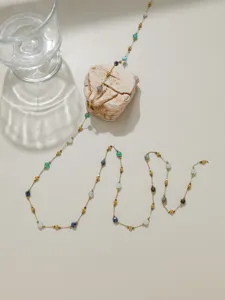 Chaîne de perles délicate avec billes métalliques et pierres colorées pour bijoux DIY.