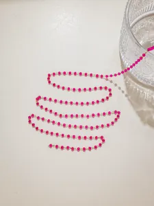Detailed close-up of pink crystal bead chain, smooth metallic links for DIY jewelry craft.
