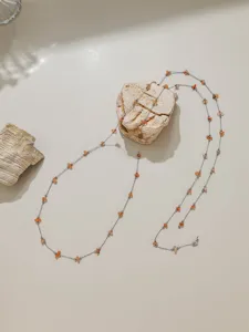 Detailed shot of stainless steel chain with orange stone chips for DIY jewelry making.