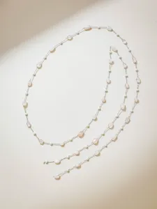 Detailaufnahme einer Edelstahlschmuckkette mit Perlen und rosa Edelsteinperlen für DIY.