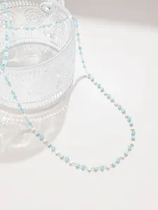 Detalle de cadena de cuentas de cristal, accesorio de joyería DIY azul claro y blanco.