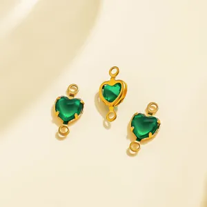 Close-up of green heart crystal DIY jewelry connector charms with dual hanging loops in gold tone.