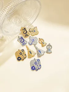 Vue détaillée de pendentifs religieux en émail bleu en acier inoxydable et breloques arabes.