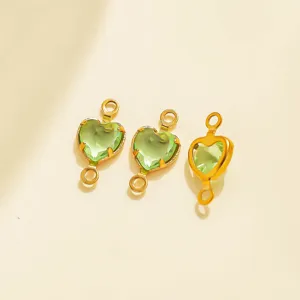Close-up of green heart-shaped crystal connectors with gold stainless steel bezels for DIY.