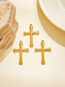 Detailaufnahme von drei goldenen Retro Edelstahl Kreuz Anhängern für DIY Schmuck Zubehör.