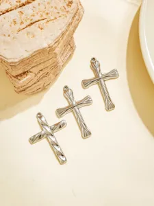 Detailaufnahme von drei retro edelstahl kreuz anhängern für diy schmuck und accessoires.
