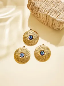 Detailaufnahme von drei goldenen Edelstahlanhängern mit bösem Blick, ideal für DIY-Schmuck.