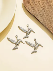 Close-up of silver hummingbird charms, detailed metal pendant craft, ideal for DIY jewelry making.