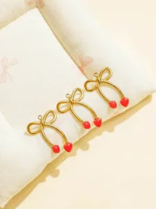 Gold-tone stainless steel bow cherry heart pendant detail for DIY jewelry making and crafts.