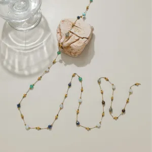 Délicate chaîne de perles matériel de bijouterie avec pierres colorées et maillons dorés.