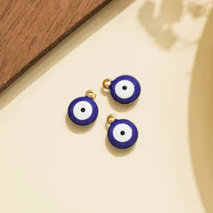 Detailansicht von drei blauen Nazar Auge Anhängern mit goldenen Ösen zum Basteln.