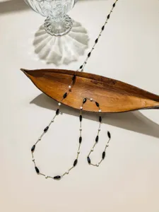 Close-up detail of mixed teardrop beads and pearls on chain for DIY jewelry making.