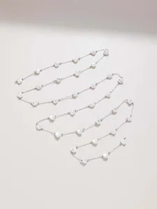 Close-up detail of irregular faux pearl chains, delicate metal links for DIY crafts.