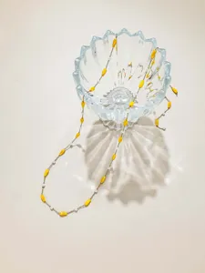 DIY jewelry making material featuring yellow drop beads and white pearls on a gold chain.
