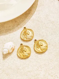 Nahaufnahme von Vintage Goldmunzen Anhangern mit gepragtem Portratdesign und praktischer Ose.