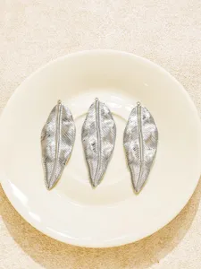 Detailansicht von drei vintage edelstahl blattanhängern für diy schmuckherstellung.