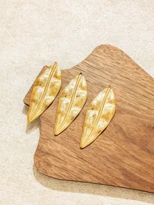 Detailaufnahme von goldenen Blatt-Metallanhängern mit strukturierten Adern für DIY-Schmuck.