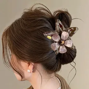 Detailansicht der stilvollen Acetat Blumen Stern Haarklammer sicher am Haarknoten getragen.