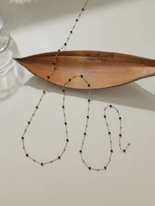 Delicate stainless steel beaded chain material for DIY jewelry making, elegant black and gold design.