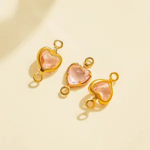 Close-up of gold-plated pink heart crystal charm connectors for DIY jewelry making details.