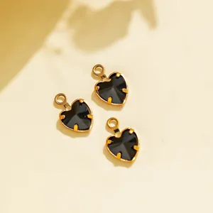Close-up of black heart pendants with gold claw settings, ideal for DIY jewelry crafting.