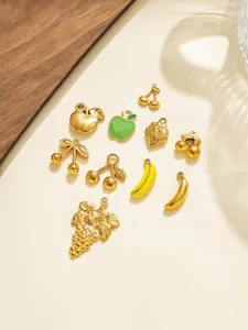 Closeup stainless steel fruit charms set, detailed 3D cherry and banana pendant jewelry DIY.