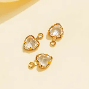 Close-up detail of heart-shaped crystal charms with golden stainless steel bezel for DIY jewelry.