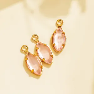 Close-up details of pink marquise crystal charms with gold bezels for DIY jewelry making.