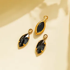 Closeup of marquise black stone pendant with gold stainless steel bezel for DIY jewelry.