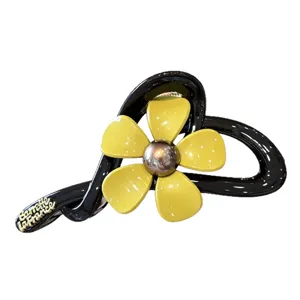 Elegante schwarze Haarklammer mit gelbem Blumendesign und goldenem Metallkern für Damen.