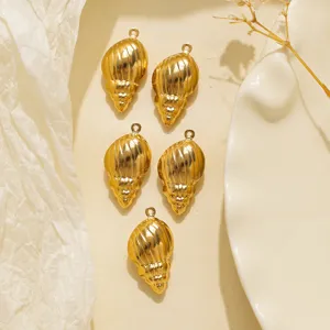 Gros plan de pendentifs coquillage dorés vintage, parfaits pour la création de bijoux DIY.