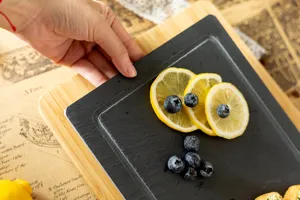 Rectangular black slate plate with bamboo wooden tray for steak sushi detail view