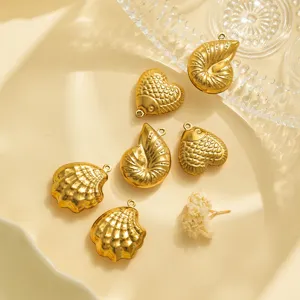 Detalle en primer plano de dijes de concha de pescado de acero inoxidable dorado para joyas.