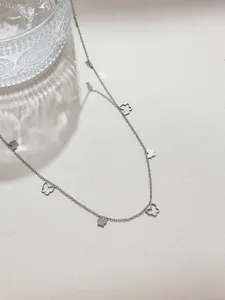 Primo piano catena argentata con ciondoli a farfalla, ideale per creazione gioielli fai da te.