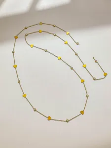 Primo piano della catena multi-elemento DIY color oro con cuori gialli e strass trasparenti.