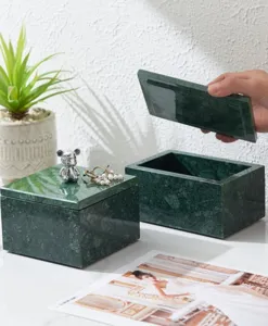Detail shot of luxury natural green marble jewelry box with elegant silver bear ornament.