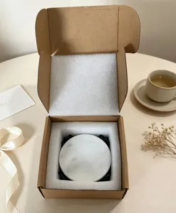Detailansicht des runden Naturmarmor-Untersetzers mit Metallhalter in edler Geschenkbox.