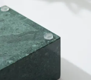 Close-up detail of the marble jewelry box bottom showing anti-slip rubber pads and stone texture.