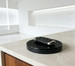Close-up detail of a modern black natural marble round tray and soap dish on a bright counter.