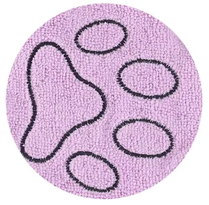 Detalle de toalla de chenilla morada para mascotas con huella bordada en negro.