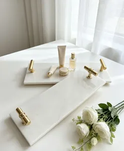 White marble tray detail with natural texture and luxurious gold handles for home decor.